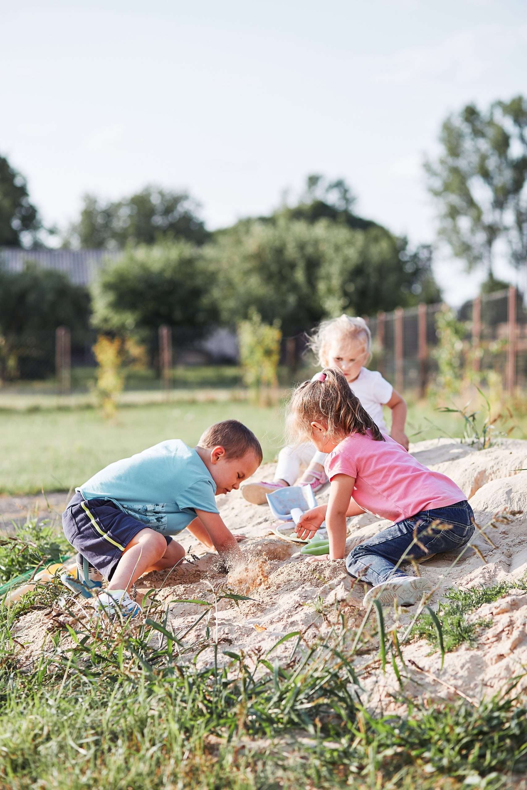 Children playing in a sandbox outside