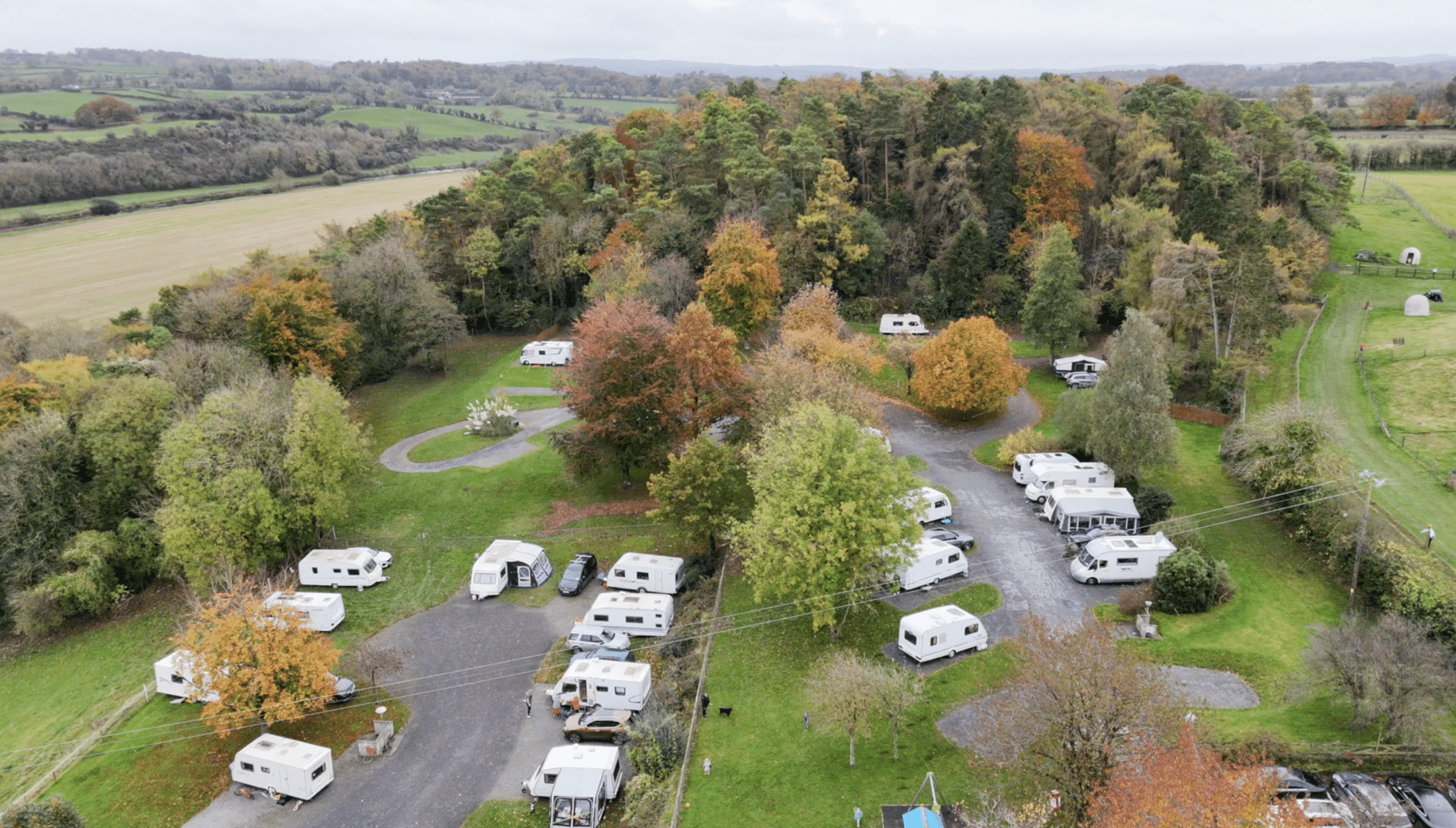 Overhead view of Nore Valley Park campsite, surrounded by green fields and trees.