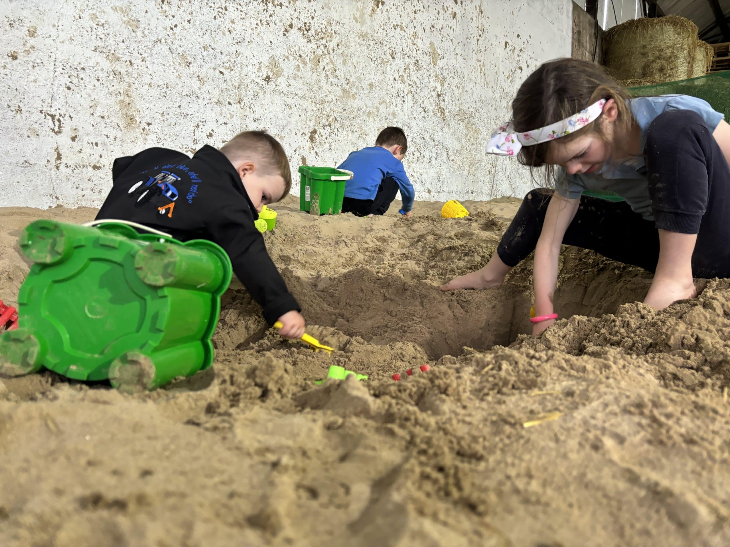 Kids playing in sand digging holes at Nore Valley.
