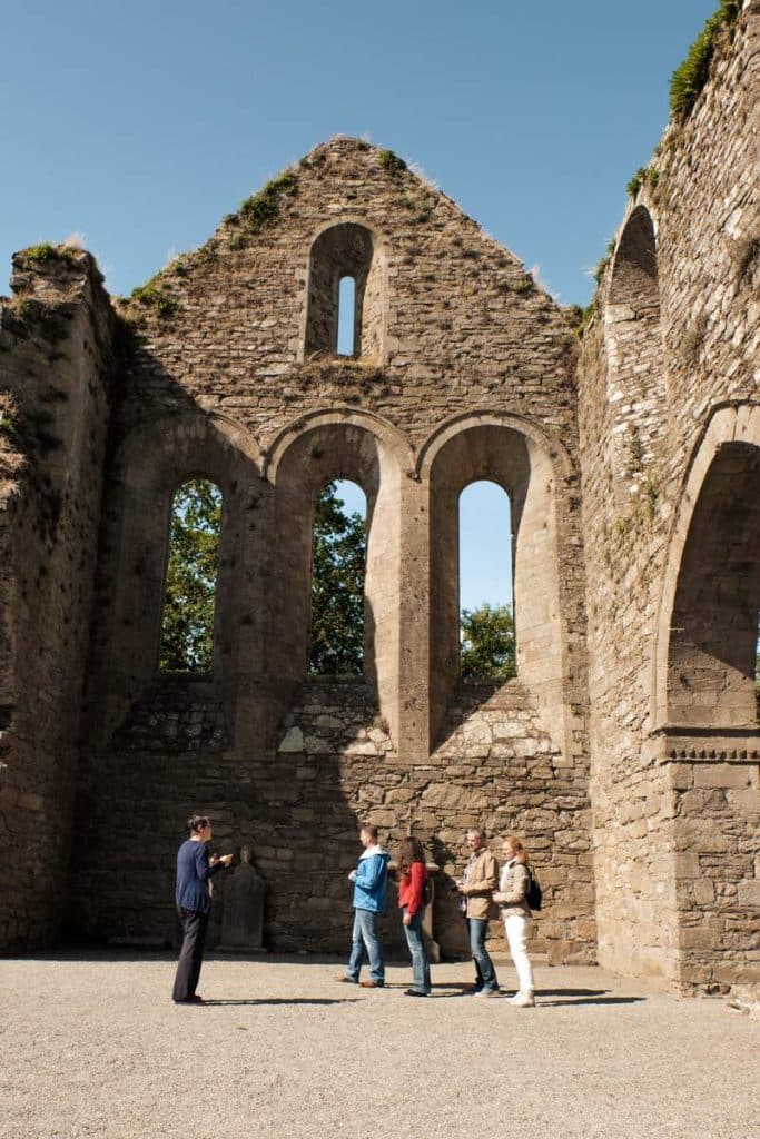 Exterior of tourists at Jerpoint Abbey Kilkenny on a sunny day.
