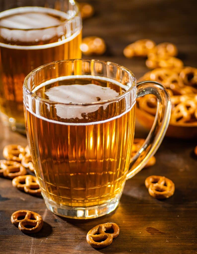 Beer in glasses with salted pretzels. On wooden background