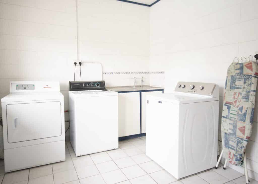 Laundry room, showing washing machines and dryer, sink and ironing board